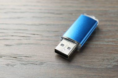 Tahta arka planda bir flaş bellek, yakın plan. Metin için boşluk