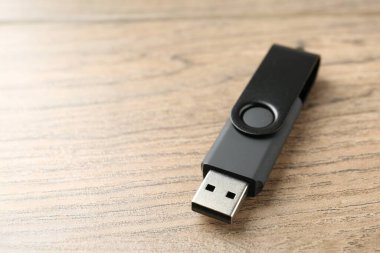 Tahta arka planda bir flaş bellek, yakın plan. Metin için boşluk