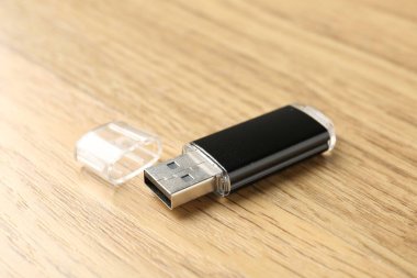 Tahta arka planda bir flaş bellek, yakın plan. Metin için boşluk