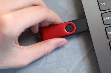 Gri masadaki flash belleğe bir kadın yerleştiriyor, üst görünüm