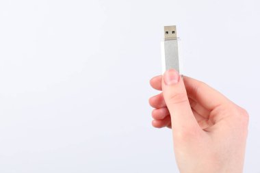 Açık gri arka planda modern flash diski olan adam, yakın plan. Metin için boşluk