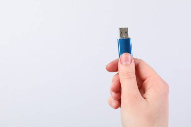 Açık gri arka planda modern flash diski olan adam, yakın plan. Metin için boşluk