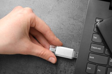 Gri masaya modern flash bellek yerleştiren adam, üst görünüm