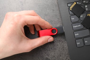 Gri masaya modern flash bellek yerleştiren adam, üst görünüm