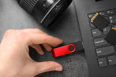 Gri masaya modern flash bellek yerleştiren adam, üst görünüm