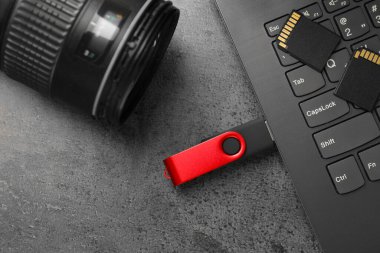 Flaş bellek, dizüstü bilgisayar, SD hafıza kartı ve kamera gri masada, düz konum