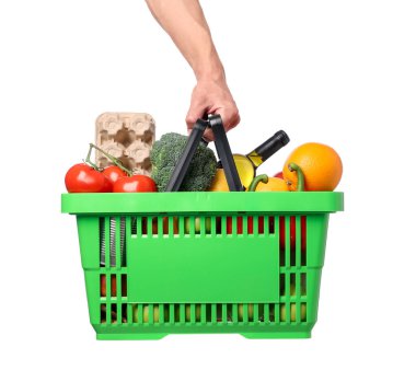 Beyaz arka planda farklı ürünleri olan alışveriş sepeti tutan adam, yakın plan.