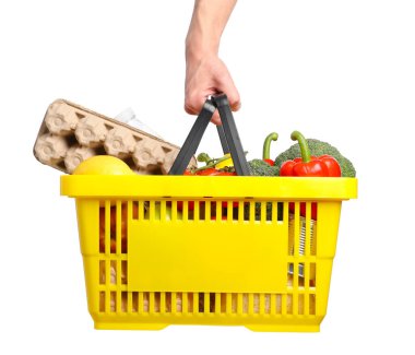 Beyaz arka planda farklı ürünleri olan alışveriş sepeti tutan adam, yakın plan.