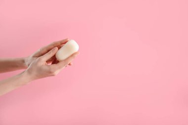 Açık pembe arka planda sabun çubuğu olan kadın, yakın plan. Metin için boşluk