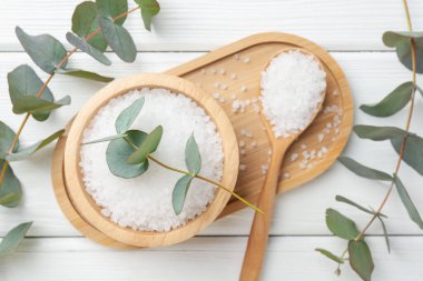 Deniz tuzu ve güzel okaliptüs dalları beyaz ahşap masa üzerinde, düz yatıyordu.