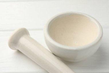 Seramik havan ve tokmak beyaz ahşap masa üzerinde, yakın çekim