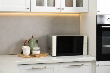 Mutfak tezgahında kapalı mikrodalga fırın.