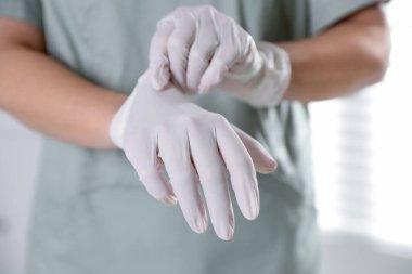 Hastanede eldiven takan tıp çalışanı, yakın plan.