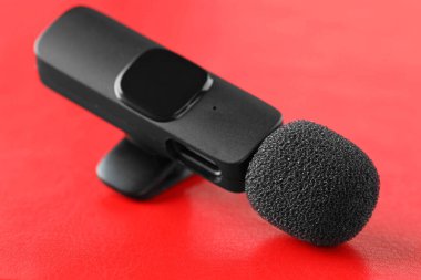 Lavalier mikrofonu kırmızı arkaplanda, yakın plan. Ses ekipmanları