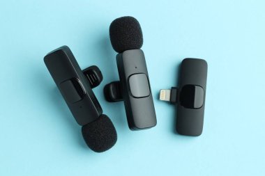Lavalier mikrofonlar ve açık mavi zemin üzerinde kablosuz alıcı, düz yatıyordu