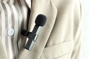 Gömleğinde lavalier mikrofon olan bir kadın, yakın plan.