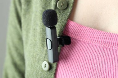 Gömleğinde lavalier mikrofon olan bir kadın, yakın plan.