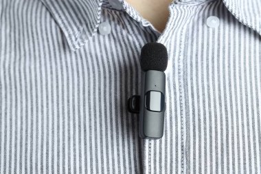 Gömleğine mikrofon takmış bir adam, yakın plan.