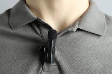 Polo tişörtüne mikrofon takmış bir adam.