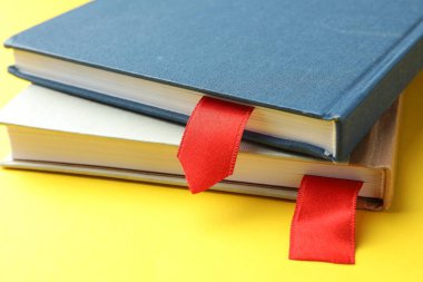 Sarı arkaplanda kırmızı kurdele yer imlerine sahip kitaplar, yakın plan