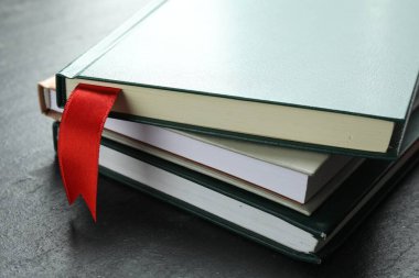 Kırmızı kurdele yer imi ve gri desenli masa üzerindeki renkli kitap, yakın plan.