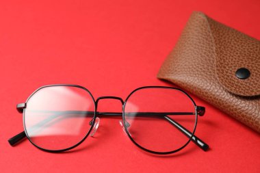 Kırmızı arka planda şık gözlüklü çanta, yakın plan