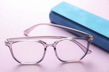 Mor arka planda şık gözlüklü çanta, yakın plan