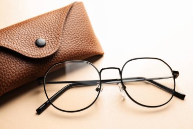 Bej arka planda şık gözlüklü çanta, yakın plan