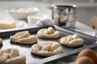 Beyaz masada pişmemiş krakerler ve malzemeler, yakın plan.