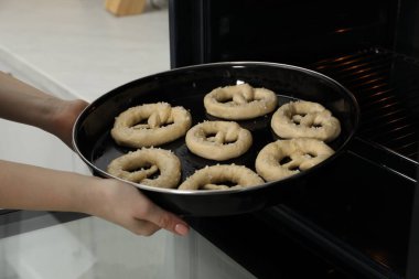 Pişmemiş krakerlerle fırına yemek koyan kadın, yakın plan.