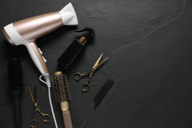 Siyah desenli arka planda farklı saç şekillendirme araçları, düz yatış. Metin için boşluk