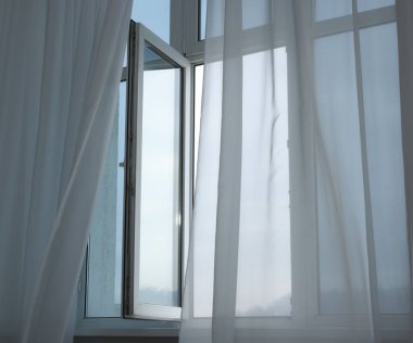 Açık pencere ve zarif beyaz perdeler. İç tasarım