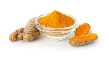 Kabın içindeki zerdeçal tozu ve beyaza izole edilmiş kökler