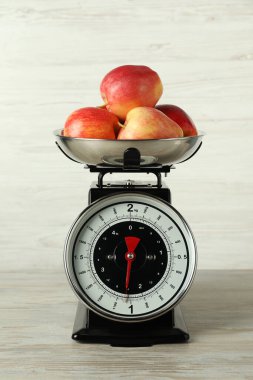 Retro mechanical kitchen scale with apples on wooden table