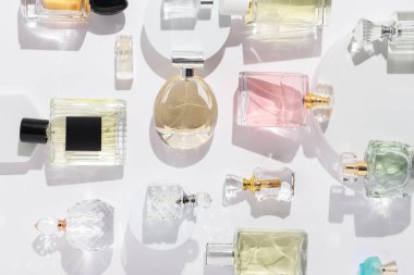 Beyaz arka planda farklı lüks parfümler, düz yatış