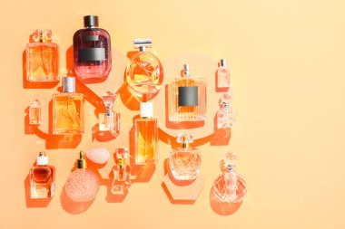 Bej arka planda farklı lüks parfümler, düz yatış. Metin için boşluk