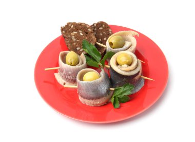 Beyaz arka planda zeytinli, maydanozlu ve ekmekli lezzetli ringa dürümleri.