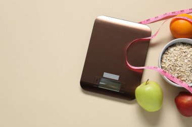 Elektronik mutfak ölçeği, mezura ve bej masadaki ürünler, düz yatak. Metin için boşluk