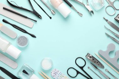 Turkuaz arka planda farklı manikür araçları çerçevesi, düz yatış. Metin için boşluk