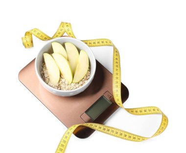 Elektronik mutfak pulları, elmalı yulaf ezmesi ve beyaz üzerine izole edilmiş mezura.