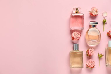 Parfüm şişeleri ve pembe arka planda güzel çiçekler. Metin için boşluk