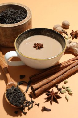Fincanda Aromatik Masala çayı, bej arka planda baharatlar ve kuru yapraklar, yakın plan