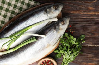 Tuzlu ringa balıkları ve baharatlar ahşap masada, düz yerde. Metin için boşluk