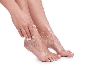 Beyaz arka planda ayaklarını ovuşturan kadın, yakın plan.