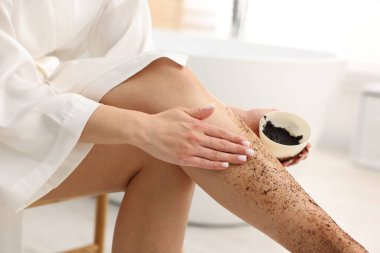 Kadın bacağını içeride ovuyor, yakın plan.