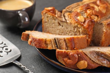 Muzlu ekmeği fındıklı kes, servis yap ve siyah masaya kahve koy, yakın plan.