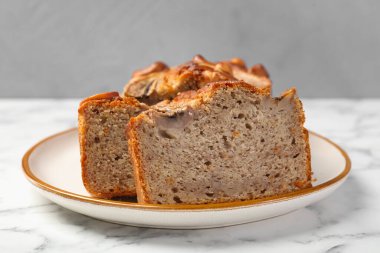 Beyaz mermer masada fındıklı muz ekmeği kes, yakın plan.