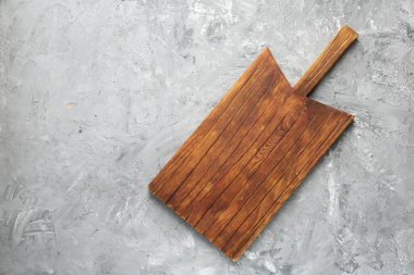 Açık gri desenli bir masada ahşap servis tahtası, üst manzara. Metin için boşluk