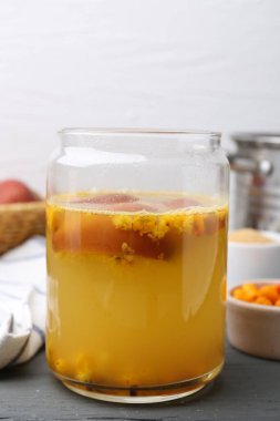 Cam kavanozda lezzetli bir karışım ve gri ahşap masada malzemeler, yakın plan.