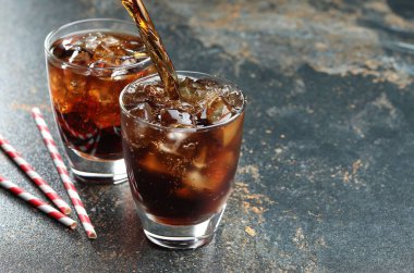 Renkli mermer masaya serinletici kola dökmek, yakın plan. Metin için boşluk